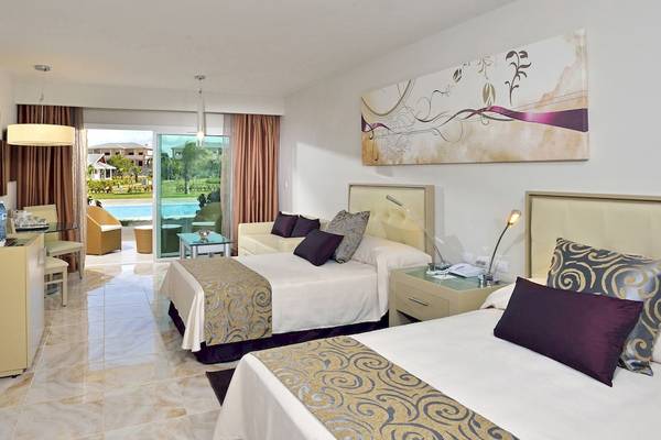 Hotelzimmer mit zwei Betten, Tisch, Fernseher, und Poolblick