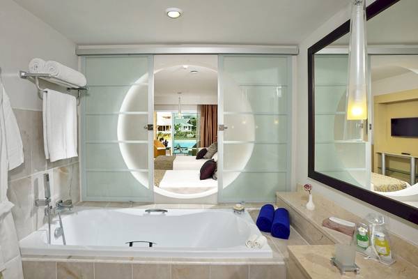 Ein Badezimmer im Paradisus Varadero Resort & Spa mit Badewanne, Spiegel und Handtüchern.