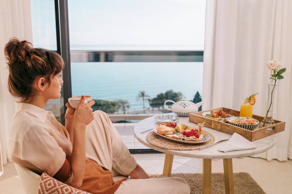 Frau im Hotelzimmer mit Meerblick am Frühstückstisch im Paradisus Varadero Resort & Spa
