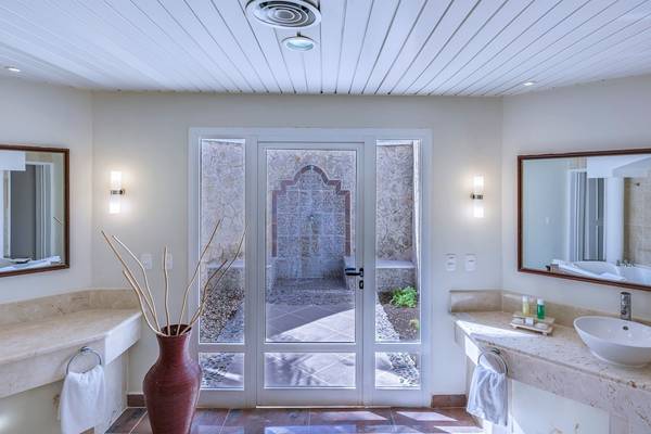 Badezimmer im Paradisus Varadero Resort & Spa mit zwei Waschbecken, Spiegeln und einer Glastür.
