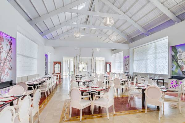 Innenbereich des Restaurants im Paradisus Varadero Resort & Spa mit weißen Stühlen und Tischen