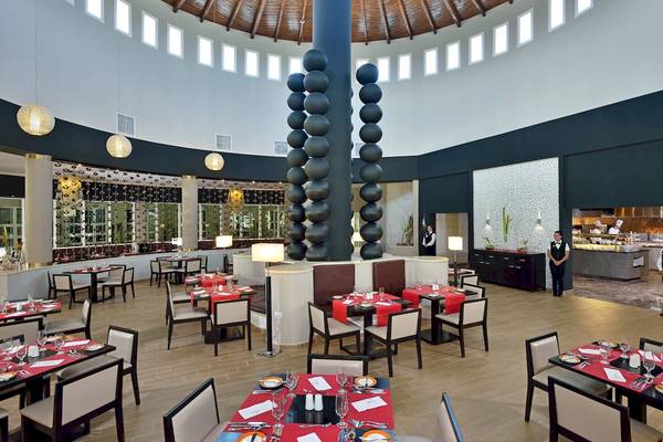 Innenraum des Restaurants im Paradisus Varadero Resort & Spa mit vielen runden Tischdecken und großen schwarzen Skulpturen.