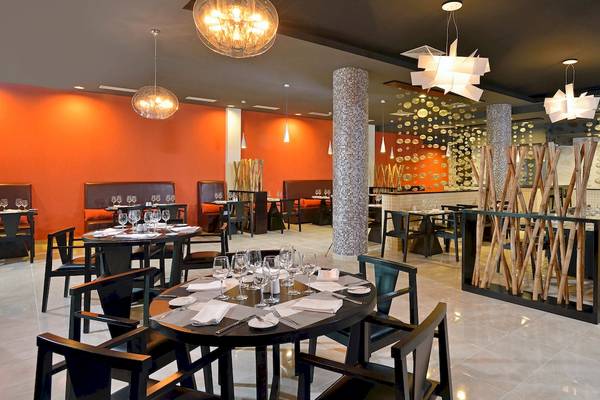 Innenansicht des Restaurants im Paradisus Varadero Resort & Spa mit modernem Design, runden Tischen und Glasdekorationen.