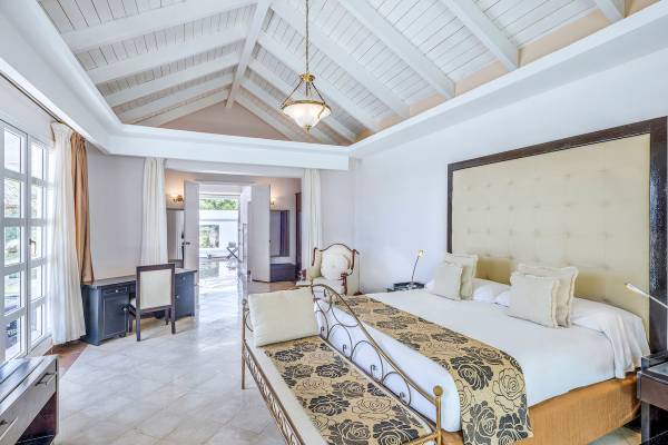 Schlafzimmer im Paradisus Varadero Resort & Spa mit weißen Wänden, einer großen Bett, Schreibtisch und Stühle.