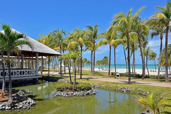 Außenbereich des Paradisus Varadero Resort & Spa mit tropischen Palmen und einem kleinen Teich.