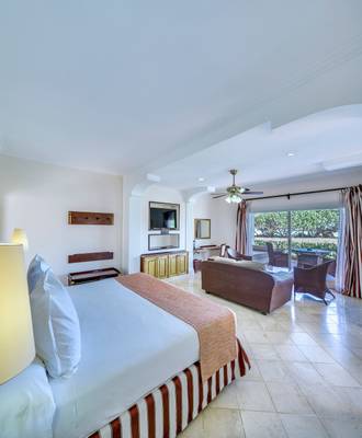 Schlafzimmer im Paradisus Varadero Resort & Spa mit großem Bett, Wohnzimmerbereich und Blick auf den Garten