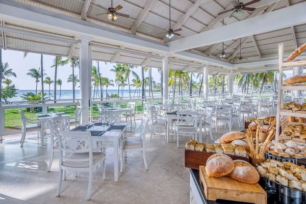 Innenansicht des Restaurants im Paradisus Varadero Resort & Spa mit weißen Tischen und Stühlen und Blick auf das Meer.