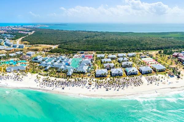 Luftaufnahme des Paradisus Varadero Resort & Spa, das an einer weißen Sandstrand liegt, mit vielen Gebäuden und Bäumen.