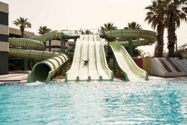 Wasserrutschen im Arina Beach Resort mit einem Kind, das auf einer Rutsche rutscht.