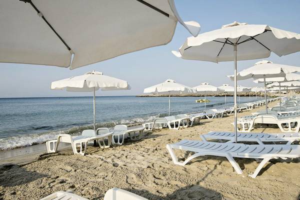 Strand mit weißen Liegen und Sonnenschirmen, Blick auf das Meer