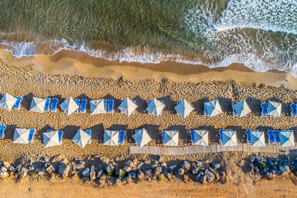 Luftaufnahme eines Strandes mit Sonnenschirmen und Sonnenliegen am Arina Beach Resort