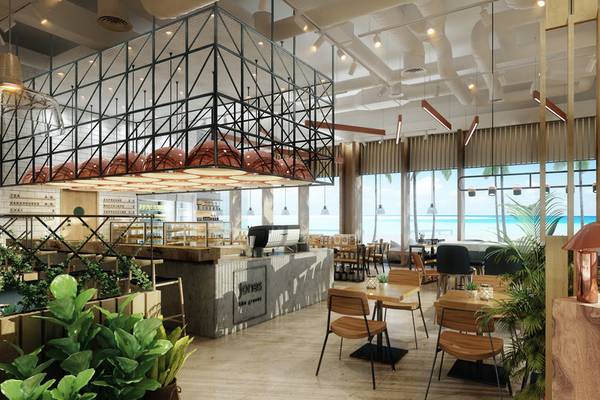 Innenansicht des Cafés im Hilton Dubai Palm Jumeirah mit Möbeln, Pflanzen und Blick auf das Meer.