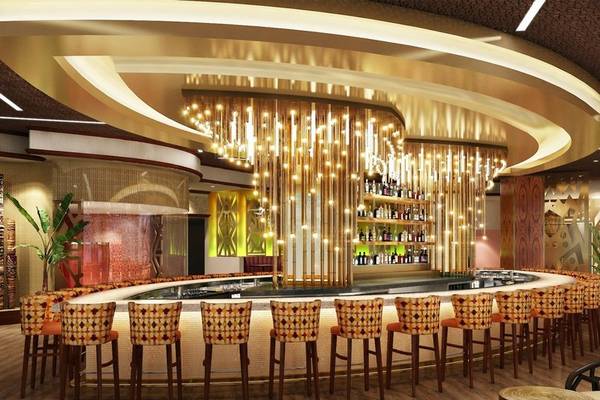 Innenansicht der Lobbybar im Hilton Dubai Palm Jumeirah mit goldenen Kronleuchtern und runden Stühlen.
