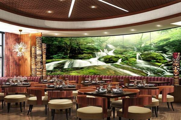 Innenansicht des Restaurants im Hilton Dubai Palm Jumeirah mit grünem Wasserfall-Wandbild.