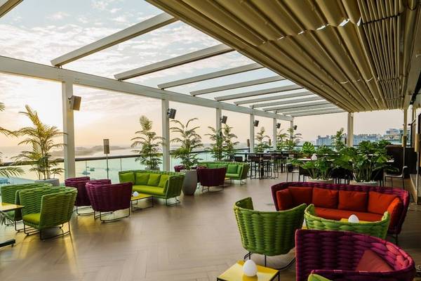 Loungebereich im Hilton Dubai Palm Jumeirah mit bunten Sitzmöbeln und Blick aufs Meer.