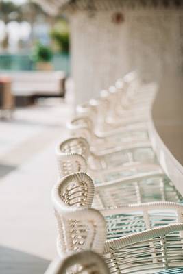 Reihe von weißen Rattan-Stühlen am Hilton Dubai Palm Jumeirah