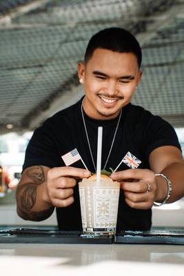 Barkeeper des Hilton Dubai Palm Jumeirah serviert einen Cocktail mit amerikanischen und britischen Flaggen.
