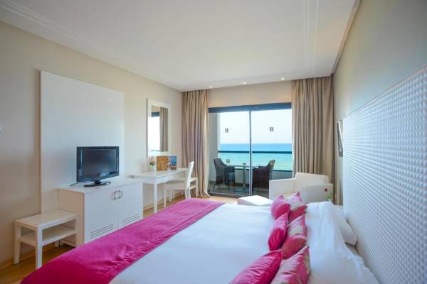 Hotelzimmer im Nozha Beach & Spa mit Meerblick, Bett, Fernseher und Balkon.