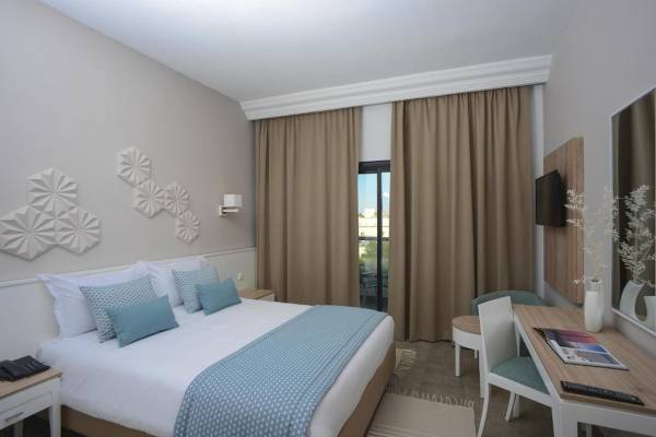 Hotelzimmer im Nozha Beach & Spa mit Bett, Schreibtisch und Fernseher.