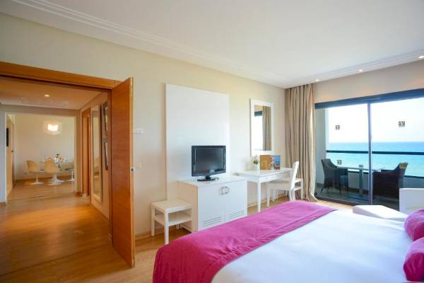 Zimmer im Nozha Beach & Spa Hotel mit Meerblick, modernem Dekor und einem großen Bett.