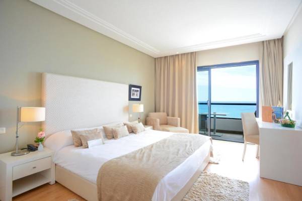 Schlafzimmer im Nozha Beach & Spa Hotel mit Blick auf das Meer.