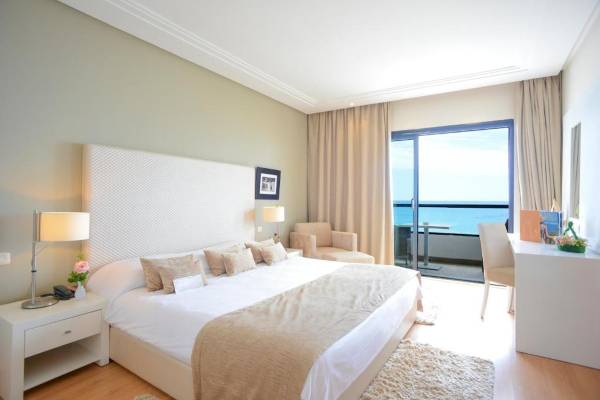 Zimmer im Nozha Beach & Spa Hotel mit Blick auf das Meer und eine Terrasse.