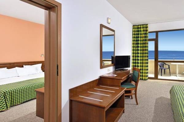 Sol Nessebar Bay Hotel Zimmer mit Meerblick, zwei Betten, Schreibtisch und Fernseher.