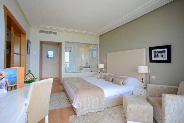 Hotelzimmer im Nozha Beach & Spa mit Bett, Nachttisch, Lampe und Sessel