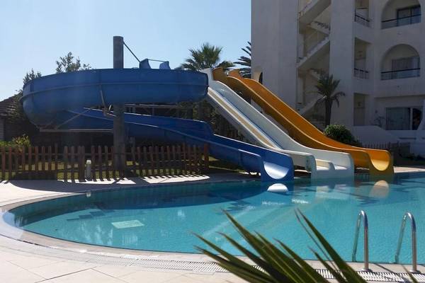 Zwei blaue und gelbe Wasserrutschen vor dem Nozha Beach & Spa Hotel.