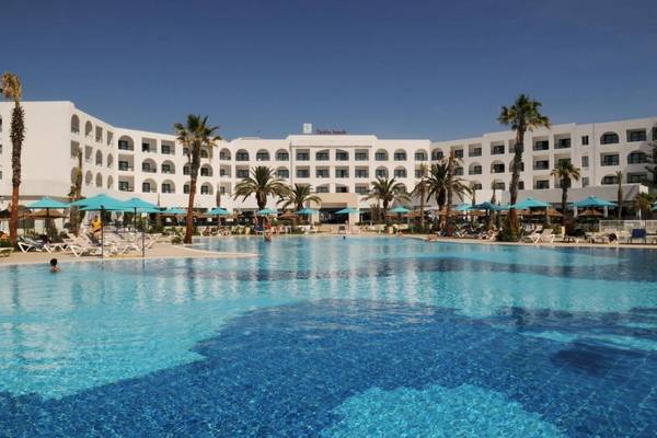 Außenbereich des Nozha Beach & Spa Hotels mit großem Pool und Sonnenliegen