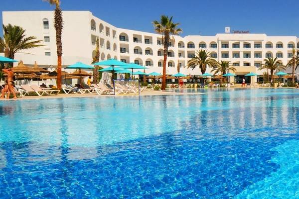 Außenpool des Nozha Beach & Spa Hotels mit Liegestühlen und Sonnenschirmen