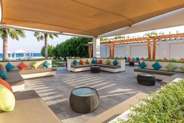 Lounge-Bereich des Sealine Beach, A Murwab Resort mit Strandblick und bunten Kissen.
