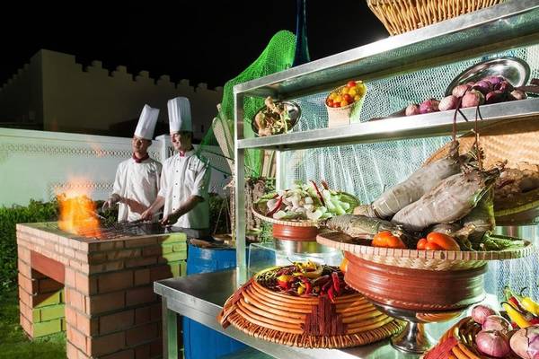 Grillstation im Sealine Beach Hotel mit Köchen und verschiedenen Gemüsesorten