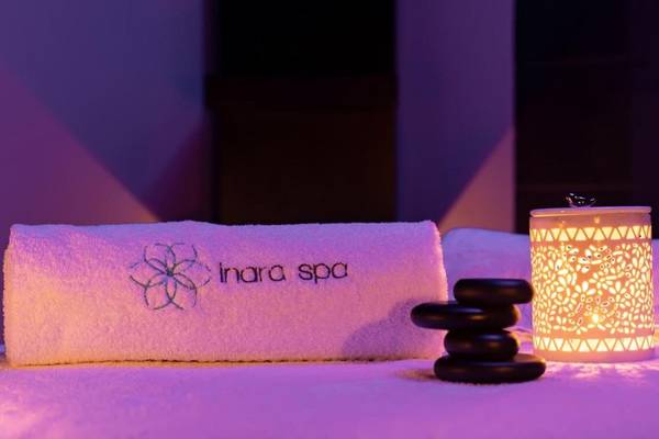 Ein Handtuch und ein Becher mit Steinen im Inara Spa bei Nacht