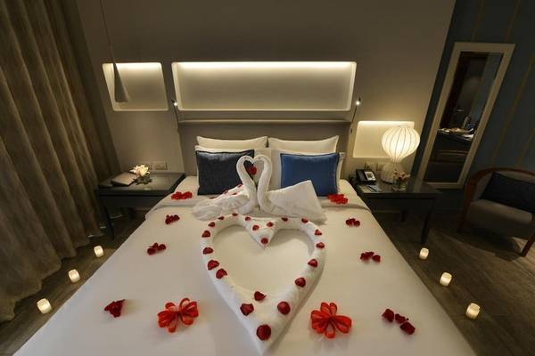 Herzförmiges Bett mit Rosenarrangement im Sealine Beach Hotel.