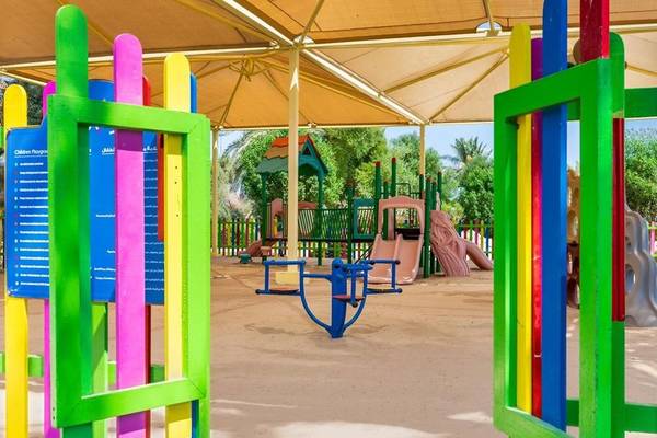 Bunte Spielgeräte und Rutschen im Sealine Beach Kinderspielplatz, A Murwab Resort.