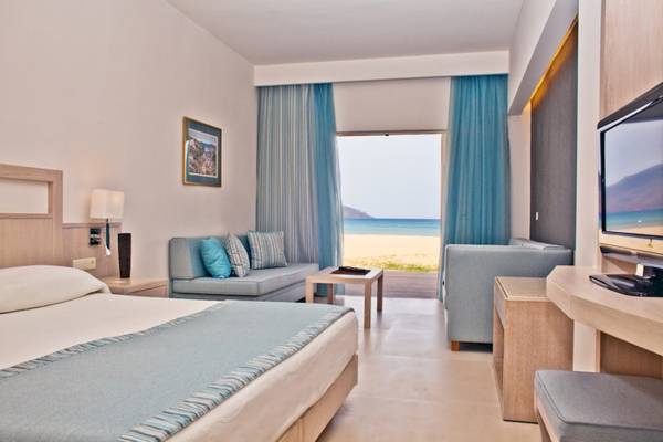 Pilot Beach Resort Zimmer mit Meerblick, Bett, Sofa, Fernseher und Fenster mit Blick auf den Strand.