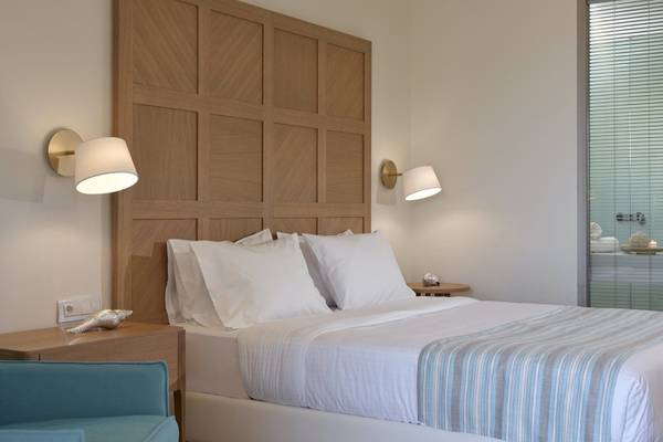 Ein modernes Hotelzimmer mit einem großen Bett und weißen Kissen im Pilot Beach Resort.