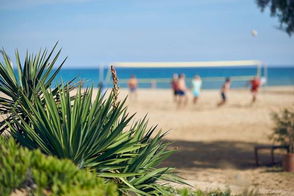 Volleyballspieler am Strand des Pilot Beach Resorts spielen ein Spiel.