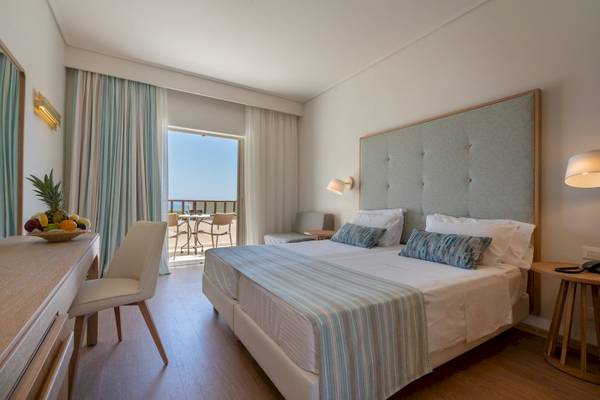 Hotelzimmer im Pilot Beach Resort mit Meerblick, Doppelbett, Balkon und Obsttablett.
