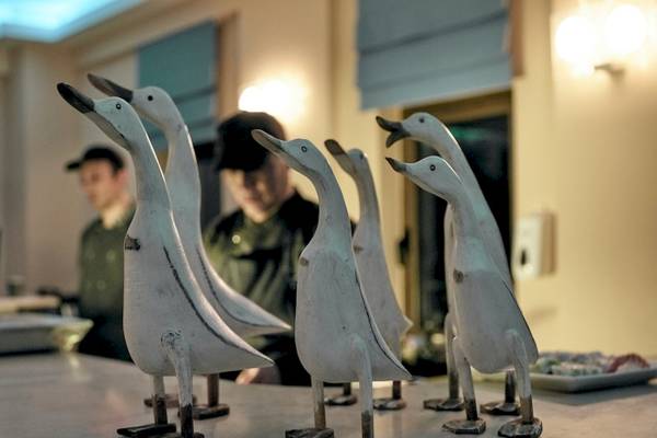 Sechs weiße Enten-Skulpturen auf einem Tisch im Pilot Beach Resort.