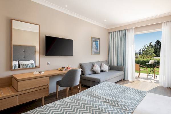 Pilot Beach Resort Hotelzimmer mit Bett, Sofa, Schreibtisch und Terrasse