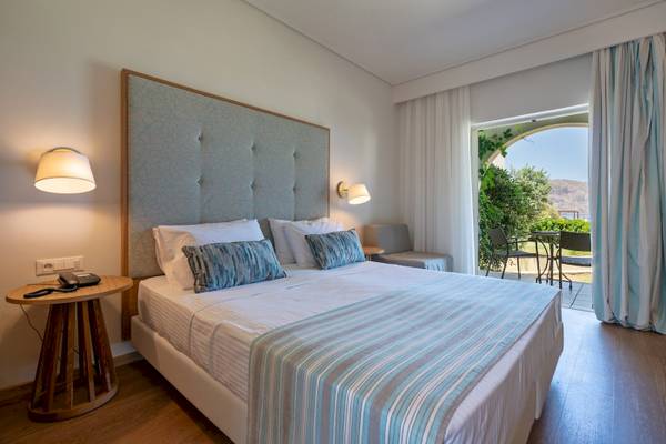 Hotelzimmer im Pilot Beach Resort mit Bett, Tisch und Terrasse.
