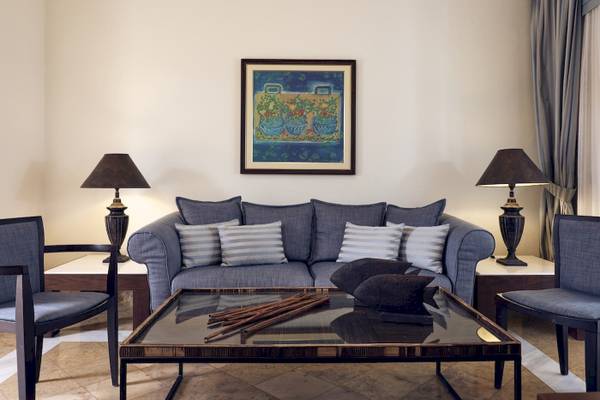Wohnzimmer des Pilot Beach Resorts mit grauem Sofa, blauer Wand und Gemälde