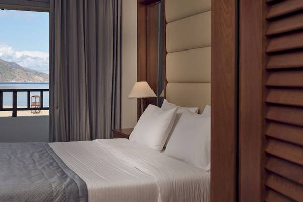 Hotelzimmer im Pilot Beach Resort mit einem Bett und Blick auf das Meer.