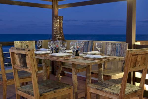 Terrasse des Pilot Beach Resort mit Blick auf das Meer bei Nacht