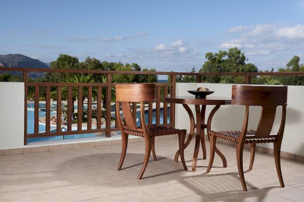 Balkon des Pilot Beach Resorts mit Tisch und Stühlen, Blick auf den Pool.
