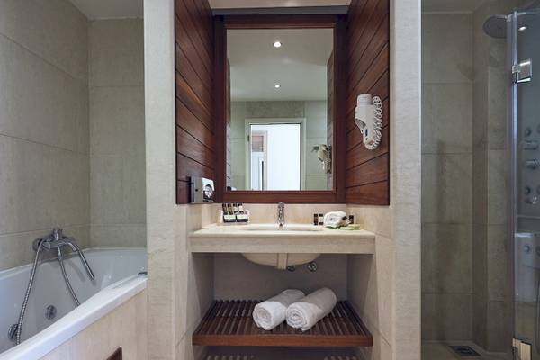 Badezimmer im Pilot Beach Resort mit Badewanne, Waschbecken und Dusche.
