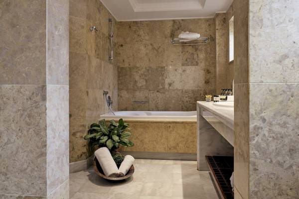 Ein Badezimmer im Pilot Beach Resort mit einer Badewanne, einer Pflanze und einem Waschbecken.