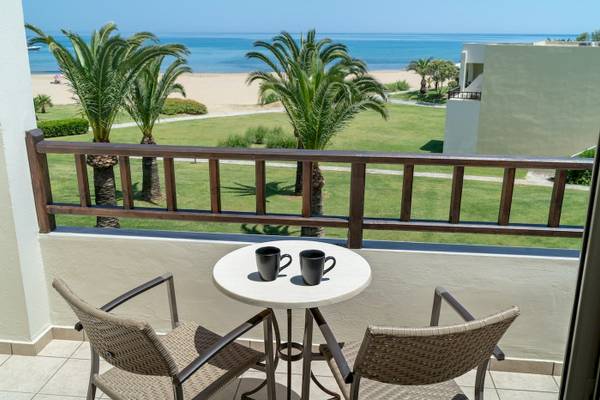 Balkon mit Blick auf das Meer vom Pilot Beach Resort mit zwei Tassen auf dem Tisch.
